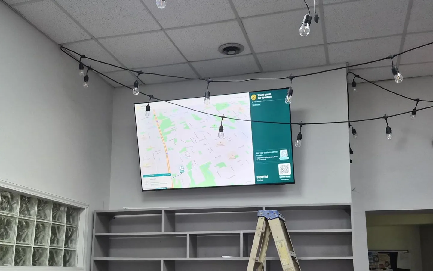 The UnityMap display on the wall at MCWS: a map of Canton beside a green sponsor board, above empty shoe racks